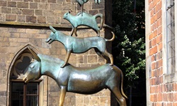Die Bronzestatue der Bremer Stadtmusikanten neben dem Bremer Roland.