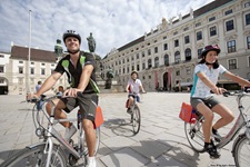 Drei Radler vor der Wiener Hofburg.