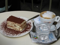 Ein Teller mit Tiramisu und eine Tasse Wiener Melange in einem typischen Wiener Kaffeehaus.