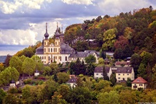 Die auf dem Nikolausberg gelegene Wallfahrtskirche Käppele in Würzburg wird idyllisch von Wald umrahmt.