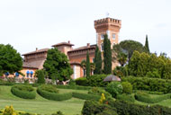 Villa Poggio San Felice in Florenz (Italien) mit ihren markanten, rot gedeckten Türmen und den üppigen gepflegten Gärten.