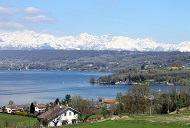 Landschaftsbild über ein Örtchen im Piemont, dahinter ein See